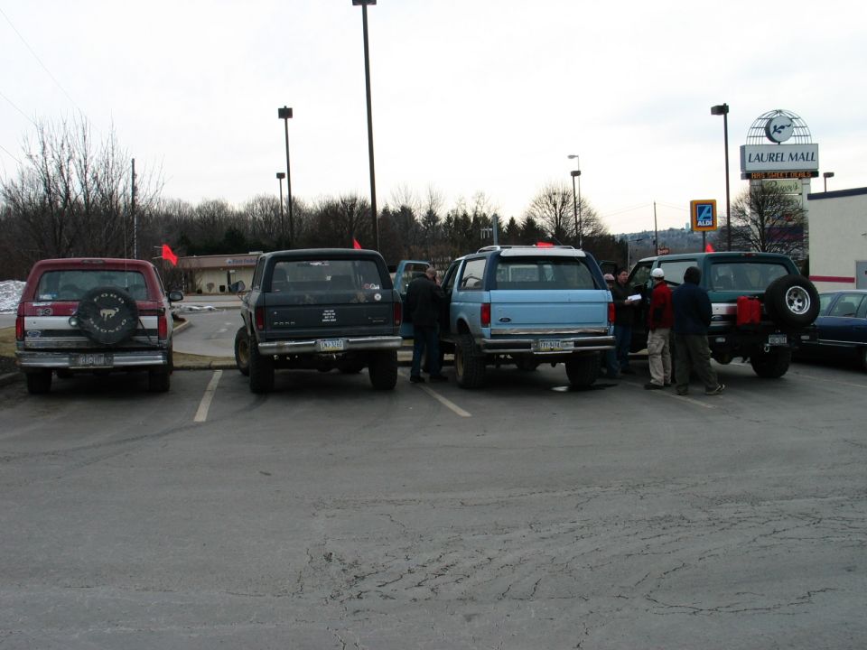 Rear view of a light blue 1995 Ford Bronco parked next to a dark green one