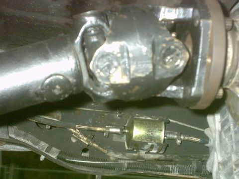1992 Ford Bronco - Underside view shows a vehicle's driveshaft U-joint and a fuel filter assembly.