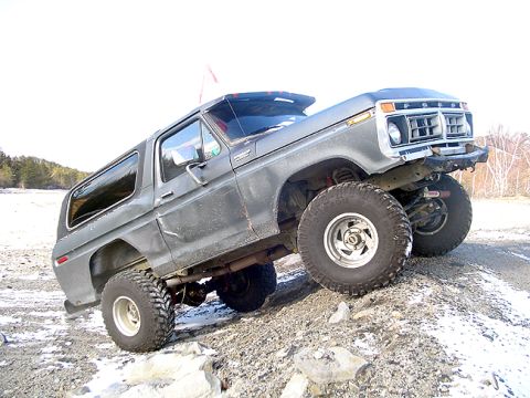 1979 Ford Bronco - This modified Ford Bronco is shown off-road on a rocky, snow-dusted surface.