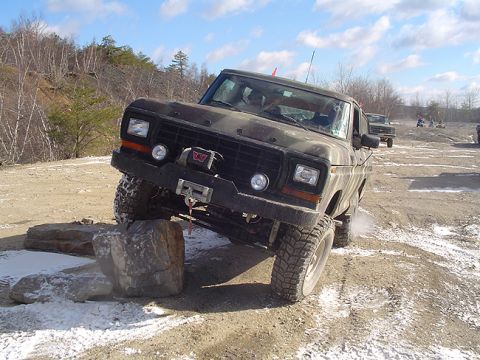 1979 Ford Bronco - Ford Bronco tackles a challenging off-road course with multiple vehicles present.