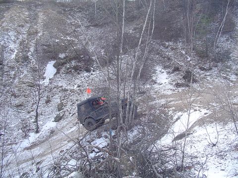 1979 Ford Bronco - A dark SUV navigates a challenging snowy trail, with an orange flag marking its presence.