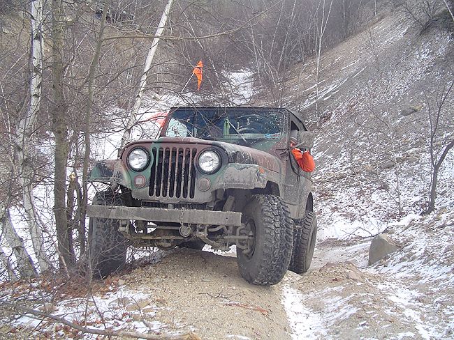 Camouflaged Jeep CJ-5 on snowy trail