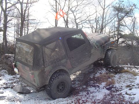 1979 Ford Bronco - A Jeep CJ-7 navigates a challenging off-road course in a winter environment.