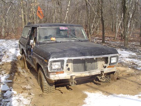 1979 Ford Bronco - This 1979 Ford Bronco is stuck in a muddy, wooded area with snow on the ground.