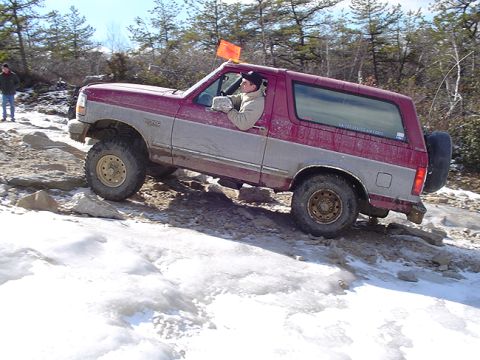 1979 Ford Bronco - This two-tone SUV navigates a challenging off-road course with icy patches and rocks.