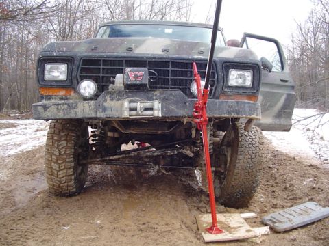 1979 Ford Bronco - This 1979 Ford Bronco, camouflaged and equipped with a winch, is stuck in the mud with a Hi-Lift jack deployed.