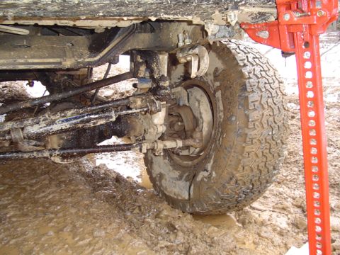 1979 Ford Bronco - A hi-lift jack is used to help free a muddy off-road vehicle stuck in the mire.