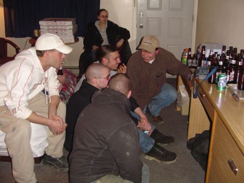 1979 Ford Bronco - A group of friends are socializing in a room, with pizza and numerous beer bottles visible.