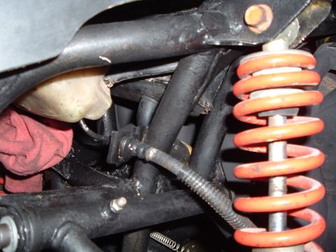 1995 Mercury Grand Marquis - This image shows a close-up view of vehicle suspension components, including a shock absorber and brake lines.