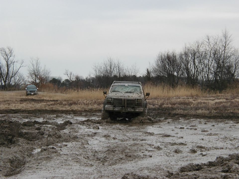 Two SUVs stuck in mud, one in the foreground, the other further back
