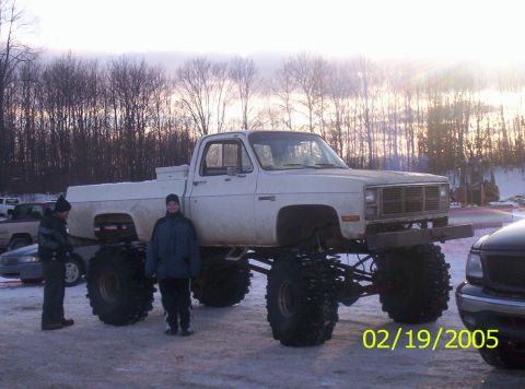 1978 Chevrolet C/K Pickup - A heavily modified pickup truck with oversized tires is parked outdoors in the snow.