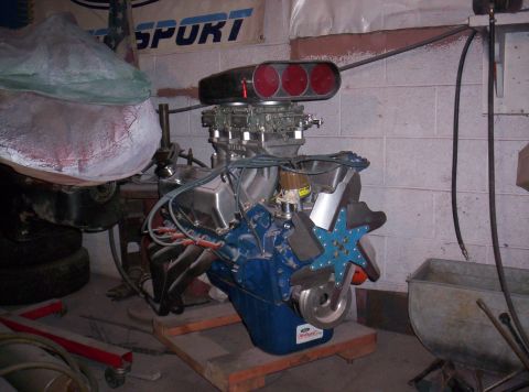 1971 Ford Mustang - A V8 engine with a prominent air intake scoop sits on a wooden pallet in a garage.
