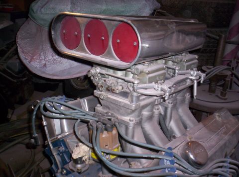 1971 Ford Mustang - Close-up of a V8 engine a triple carburetor setup and chrome air cleaner.