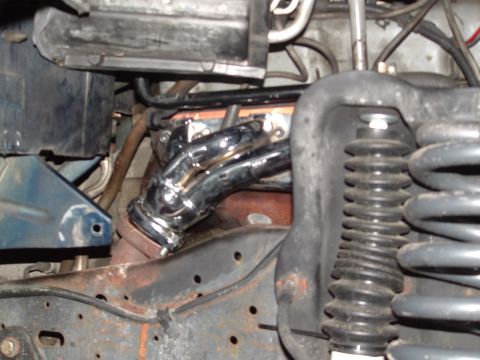 1989 Ford Bronco - Close-up view of engine components including exhaust headers and suspension parts.