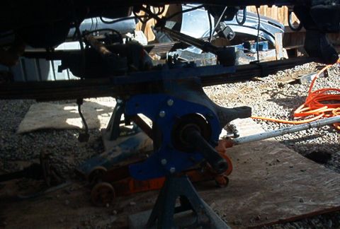 1986 Ford Bronco - Vehicle undercarriage components, including leaf springs and suspension, are visible while the vehicle is supported by jack stands.