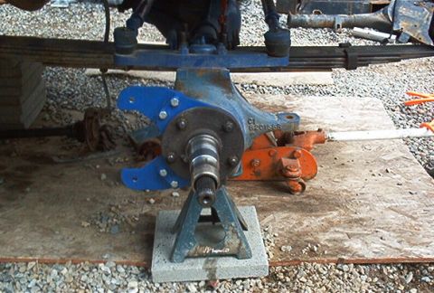 1986 Ford Bronco - Close-up of a front axle assembly blue brackets and visible part numbers.