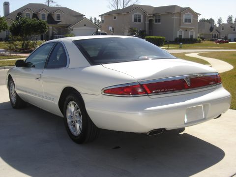 1997 Lincoln Mark VIII - Rear view of a white 1997 Lincoln Mark VIII parked on a concrete driveway with houses in the background.