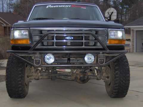 1993 Ford Bronco - Frontal view of a black Ford Bronco with a custom bumper and auxiliary lights.