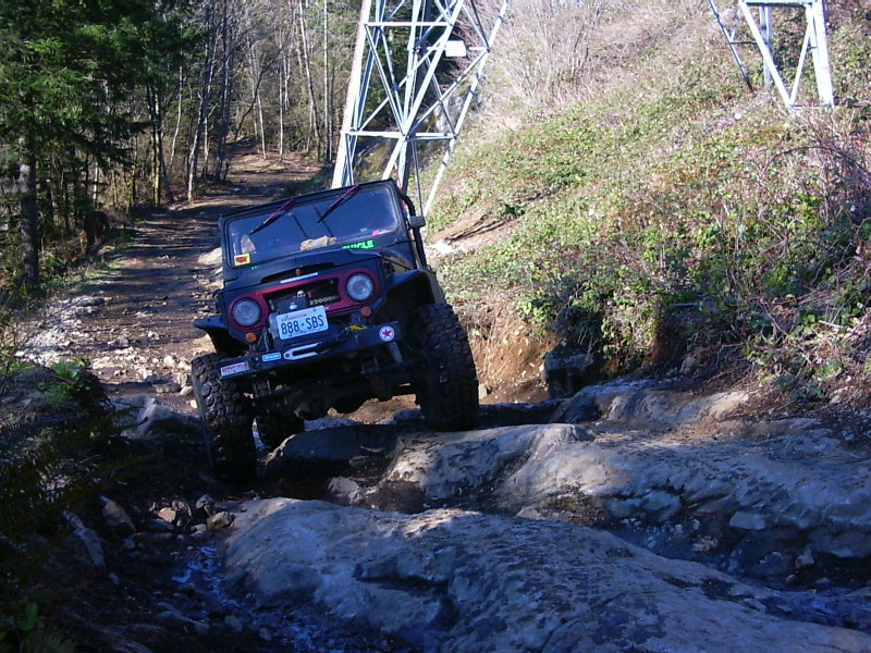 Black off-road vehicle navigating rocky terrain