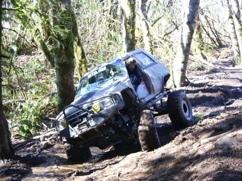 1990 Ford Bronco - This heavily modified SUV navigates a challenging muddy off-road course, its off-road capabilities.