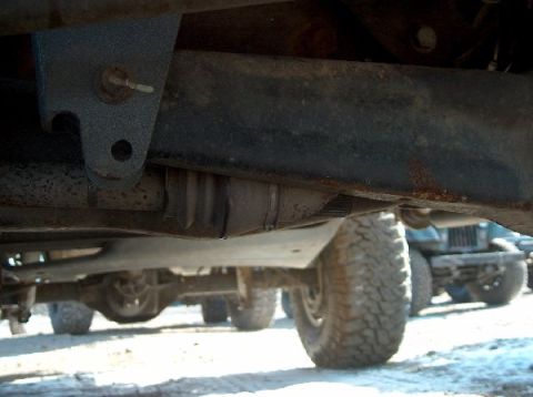1995 Ford Bronco - A low-angle view shows the undercarriage and tires of a vehicle, with other vehicles partially visible in the background.