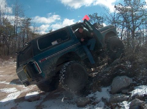 1995 Ford Bronco - This 1978 Ford Bronco is navigating a challenging off-road course with snow and rocks.