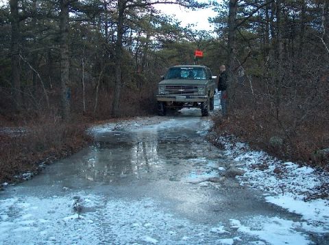 1995 Ford Bronco - Pickup truck navigates an icy path through a wooded area during winter.