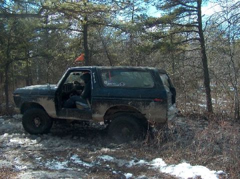 1995 Ford Bronco - Muddy 1978 Ford Bronco navigating a snowy, wooded trail.