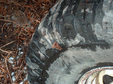 1995 Ford Bronco - A close-up view of a tire shows wear and tear, with mud and debris obscuring the tread pattern.