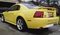 2002 Ford Mustang - Rear view of a yellow 2002 Ford Mustang, showing its distinctive taillights and spoiler.