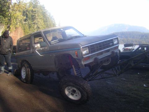 1984 Ford Bronco II - A lifted 1984 Ford Bronco II is positioned on a ramp, with another vehicle visible in the background.
