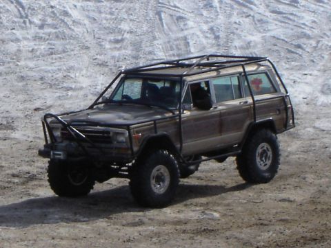 1978 Chevrolet C/K Pickup - This modified off-road vehicle, likely from the 1980s, is equipped with a custom roll cage and oversized tires.