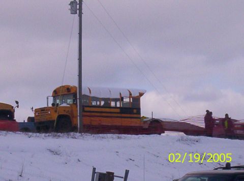 1978 Chevrolet C/K Pickup - A modified school bus sits in a snowy landscape with another vehicle nearby.