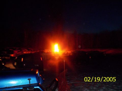 1978 Chevrolet C/K Pickup - A blue vehicle is parked at night with a bright light source in the background and other vehicles around.