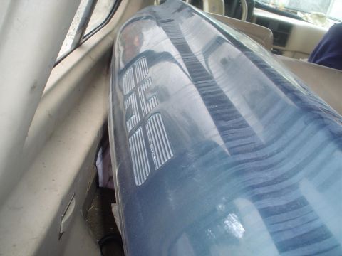 1993 Ford Taurus - A blue plastic part with embossed text is stored inside a vehicle, obscuring the interior view.