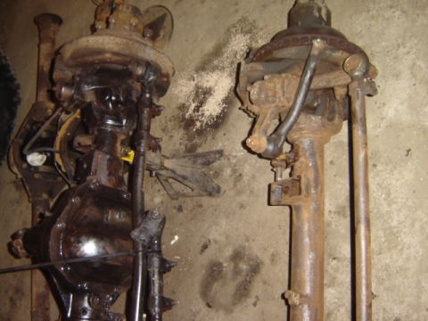 1992 Ford Bronco - Two heavily rusted Dana 60 axles are shown, one with a brake drum assembly visible.