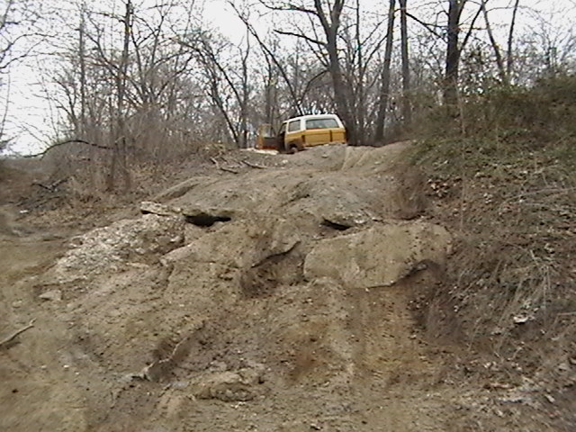 Yellow and white pickup truck on a dirt hill