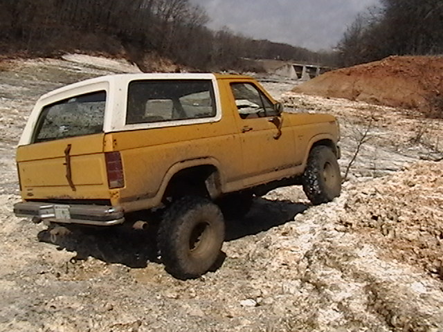 yellow SUV with white top on rocky terrain