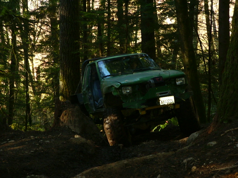 Green off-road vehicle on wooded trail, license plate AB1222L