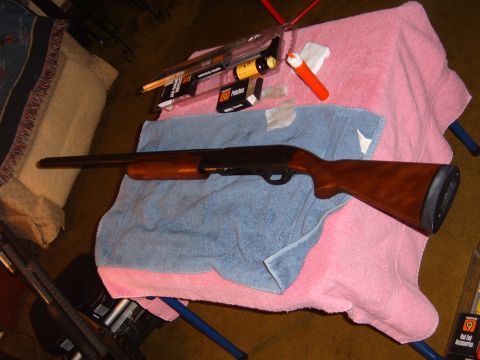 1993 Ford Bronco - A shotgun and its cleaning kit are laid out on towels.