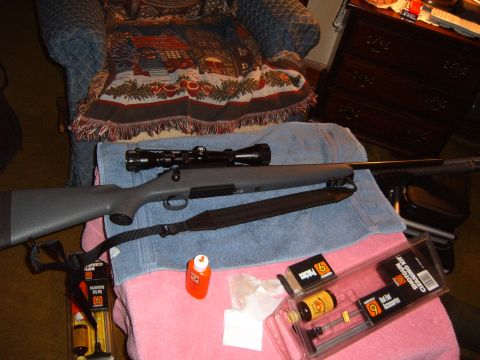 1993 Ford Bronco - A rifle and its cleaning supplies are laid out on towels in front of a chair.
