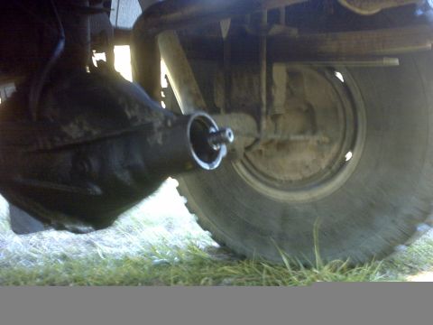 1995 Ford Bronco - Close-up view of a vehicle's rear axle and tire, with visible damage to the differential housing.