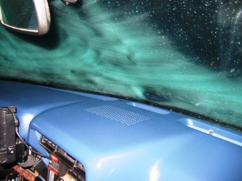 1985 Ford Bronco - Interior view of a vehicle's dashboard and windshield, showing water droplets on the glass.