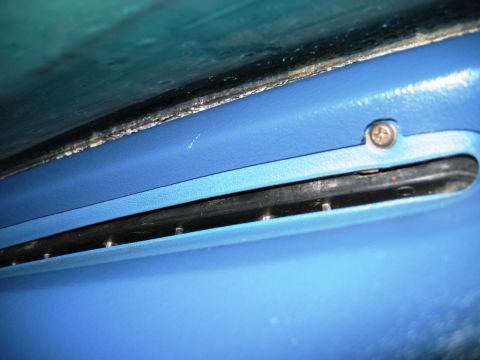 1985 Ford Bronco - Close-up of a blue dashboard vent with visible screw and black trim.