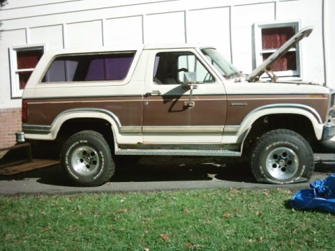 1982 Ford Bronco - Side view of a 1982 Ford Bronco, showing its two-tone paint and an open hood.