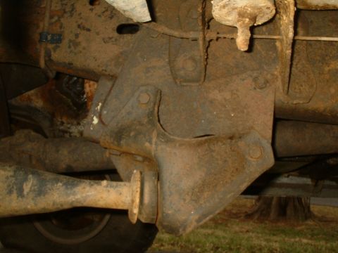 1982 Ford Bronco - Close-up view of a rusty suspension component on the underside of a vehicle.