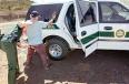 1993 Ford Bronco - Border Patrol officer detains a civilian next to a marked Border Patrol SUV.