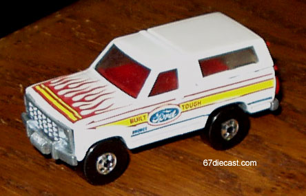 1993 Ford Bronco - A white toy Ford Bronco with flame decals on the hood and 'Built Tough' text on the side sits on a wooden surface.