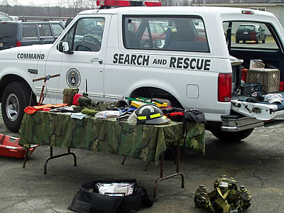 1993 Ford Bronco - A white Ford Bronco, marked "COMMAND" and "SEARCH and RESCUE", displays various equipment on tables.
