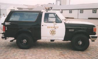 1993 Ford Bronco - This 1993 Ford Bronco is marked as a Sheriff's vehicle and features a two-tone paint scheme with a spare tire mounted on the rear.